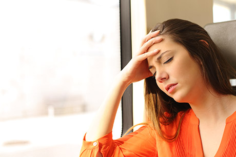 woman holding head in hand