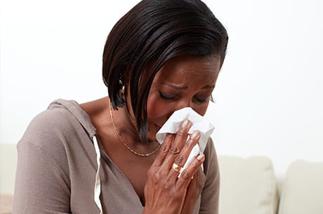 Woman blowing her nose