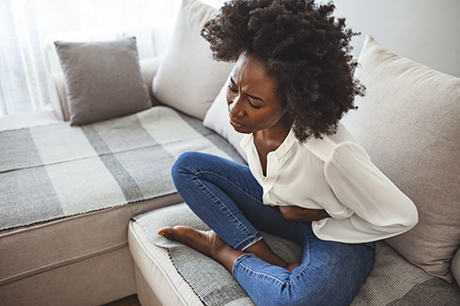 Woman with stomach pain on couch