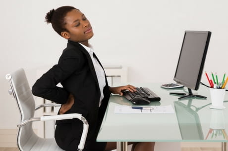 Woman in an office with back pain