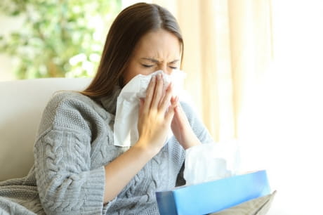 Woman blowing her nose