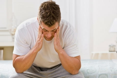 Man sad sitting on his bed