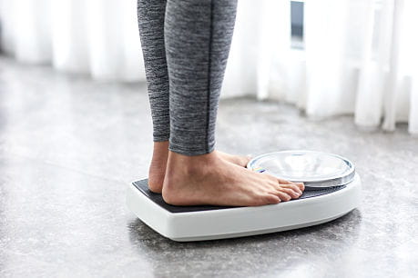Person standing on scale for diet and weight loss