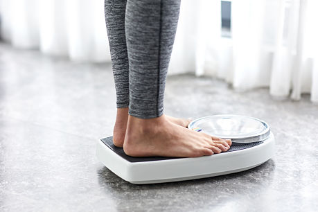 Person standing on scale for diet and weight loss