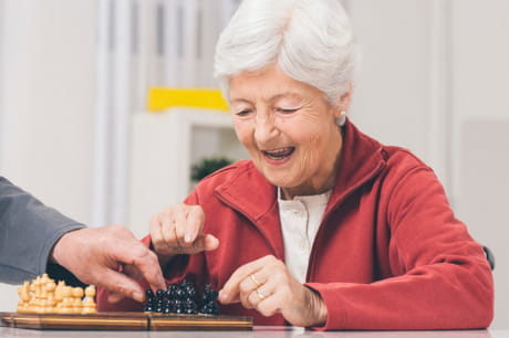 Elderly woman playing chess.