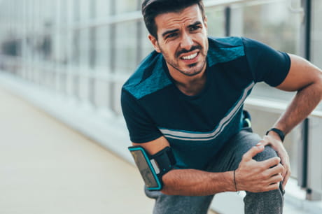Man clutches knee in pain