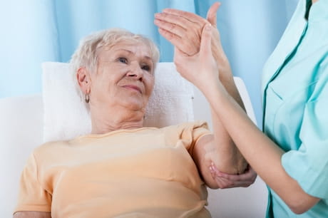Elderly woman has her arm examined.