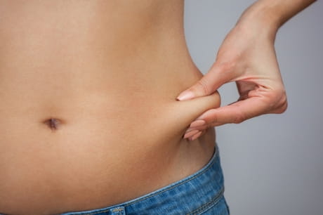 Woman pinching her waistline