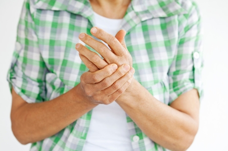 Man massaging his left hand with his right hand