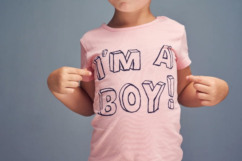 Child wearing pink t-shirt that says ‘I’m a boy.’