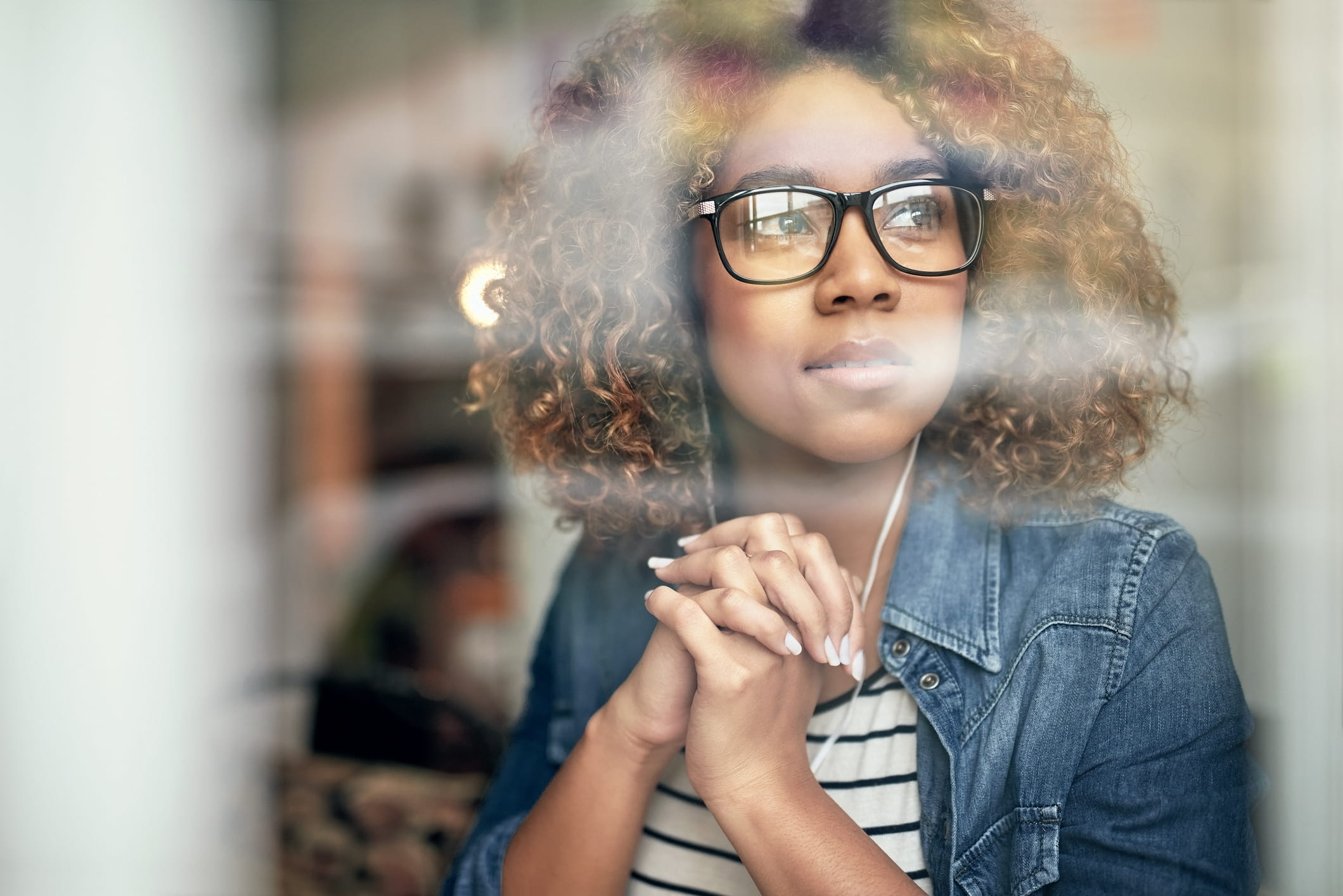 Young woman looking out the window, contemplating surgery after weight loss