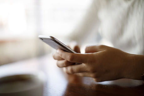 Woman charting her basal body temperature in her fertility tracking app on her smartphone.