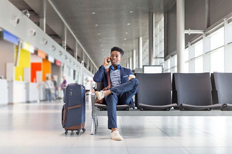 Young man talking on the phone in an airport lounge.