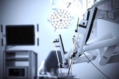 Close-up of robotic arms in an empty surgery room.