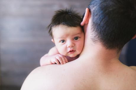 Dad bonding with this newborn through skin-to-skin contact.