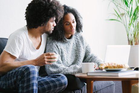 Young beautiful couple using laptop on sofa