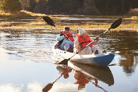 healthy older couple canoeing.