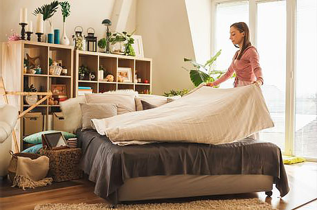 Woman deep cleaning bedroom after illness