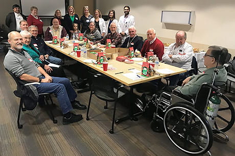 A group of cancer providers, staff and Road to Recovery drivers enjoy cookies at a holiday event