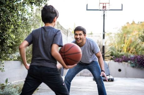 Healthy, active father and son playing basketball.