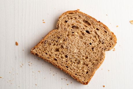 A slice of whole grain bread on a white background.