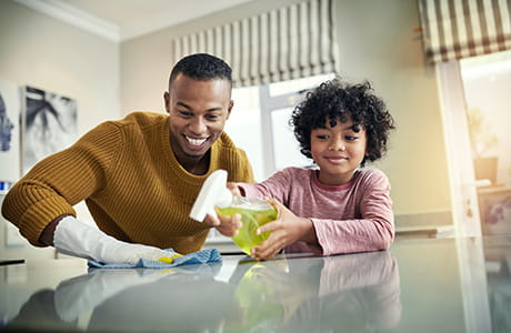 Man and child cleaning counter