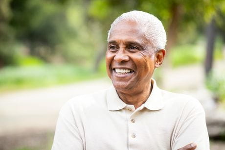 Older man smiling, outdoors.