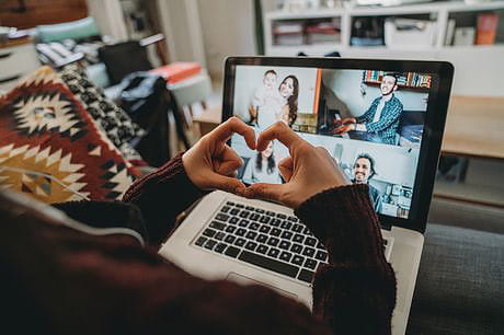 Young woman uses laptop to video chat with friends.