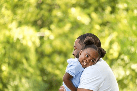 African American father hugging his young daughter