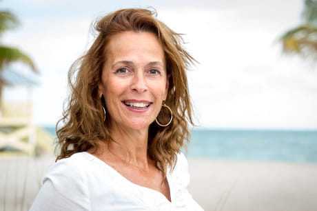 Mid 40s woman on a beach with clear skin