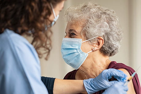 Elderly woman receiving COVID-19 vaccination.