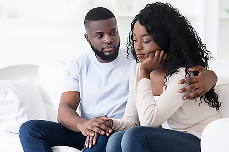 Woman being comforted by her partner following a miscarriage.