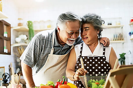 Happy couple preparing healthy food options.