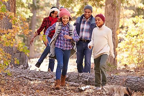 A family enjoys a fall hike in the woods.