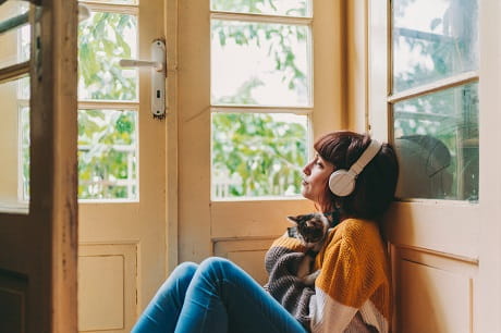 A woman practicing self-care by listening to music.