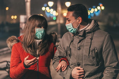 Couple wearing masks walking arm in arm