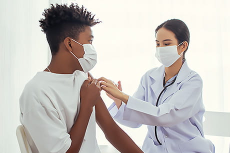 Young patient receives a flu shot from a provider.