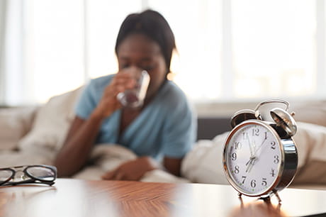 Woman waking up and drinking water