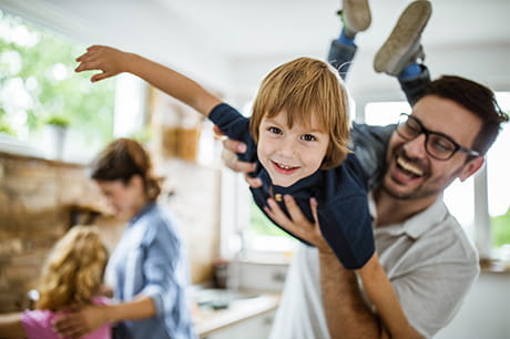 Happy family son and father playing around