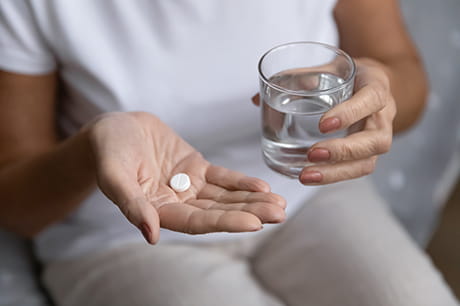 Woman taking pills with a glass of water