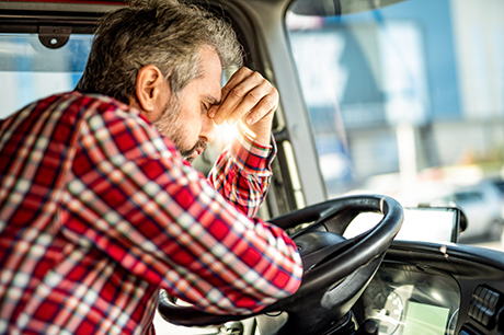 A man sitting in the car not feeling well