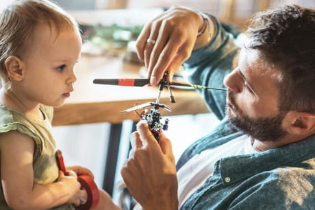 Man and child playing with a battery operated toy