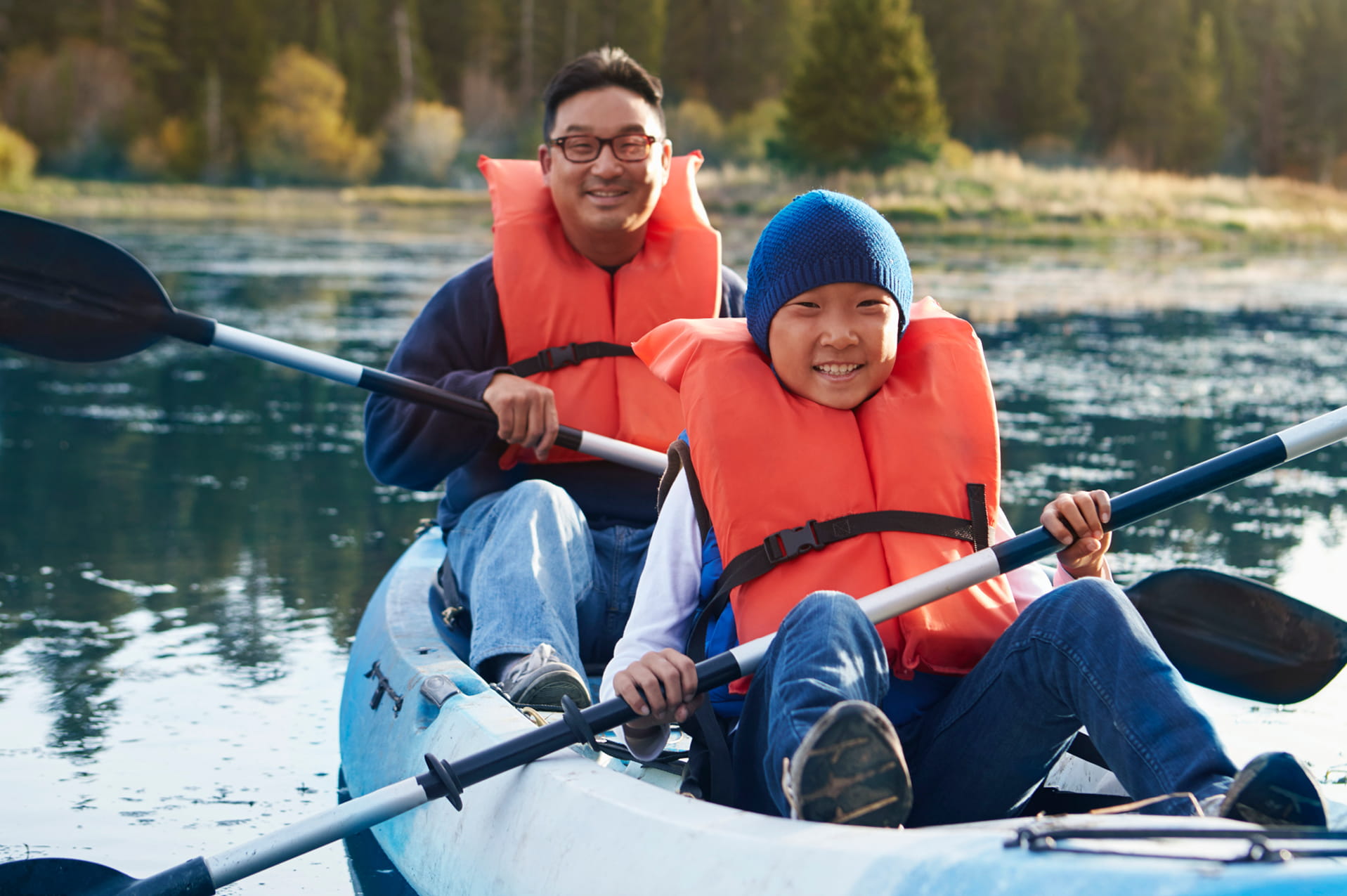 Father and son kayaking on a lake.