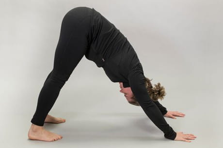 Woman practicing yoga doing a downward-facing dog pose