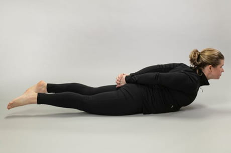 Woman practicing yoga doing a locust pose