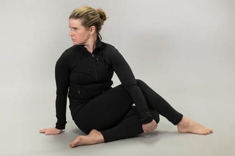 Woman practicing yoga doing a  seated spinal twist