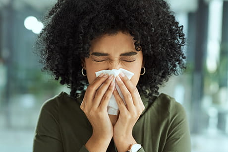 Woman blowing nose