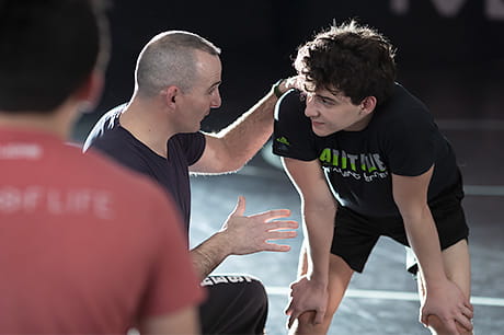 Young wrestler, Max Murray, receives instruction from his coach.