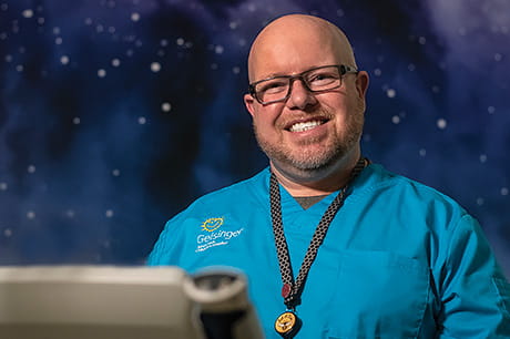 Intern and nursing assistant Joshua Reinsburrow stands in a colorful hallway within the Janet Weis Janet Weis Children’s Hospital.