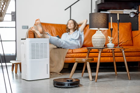 A woman next to an air filter avoiding the effects of air pollution